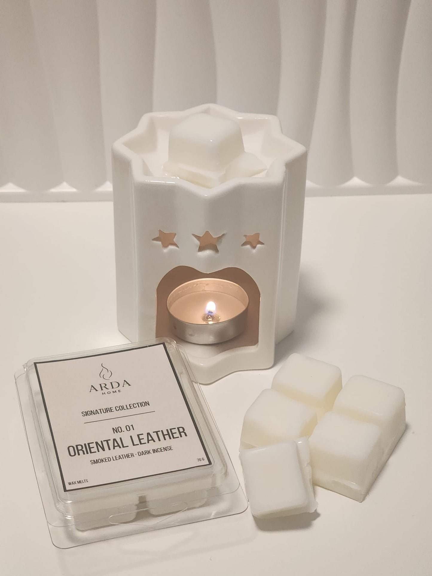 Tableta de wax melts Nº01 Oriental Leather de ARDA HOME junto a un quemador cerámico.