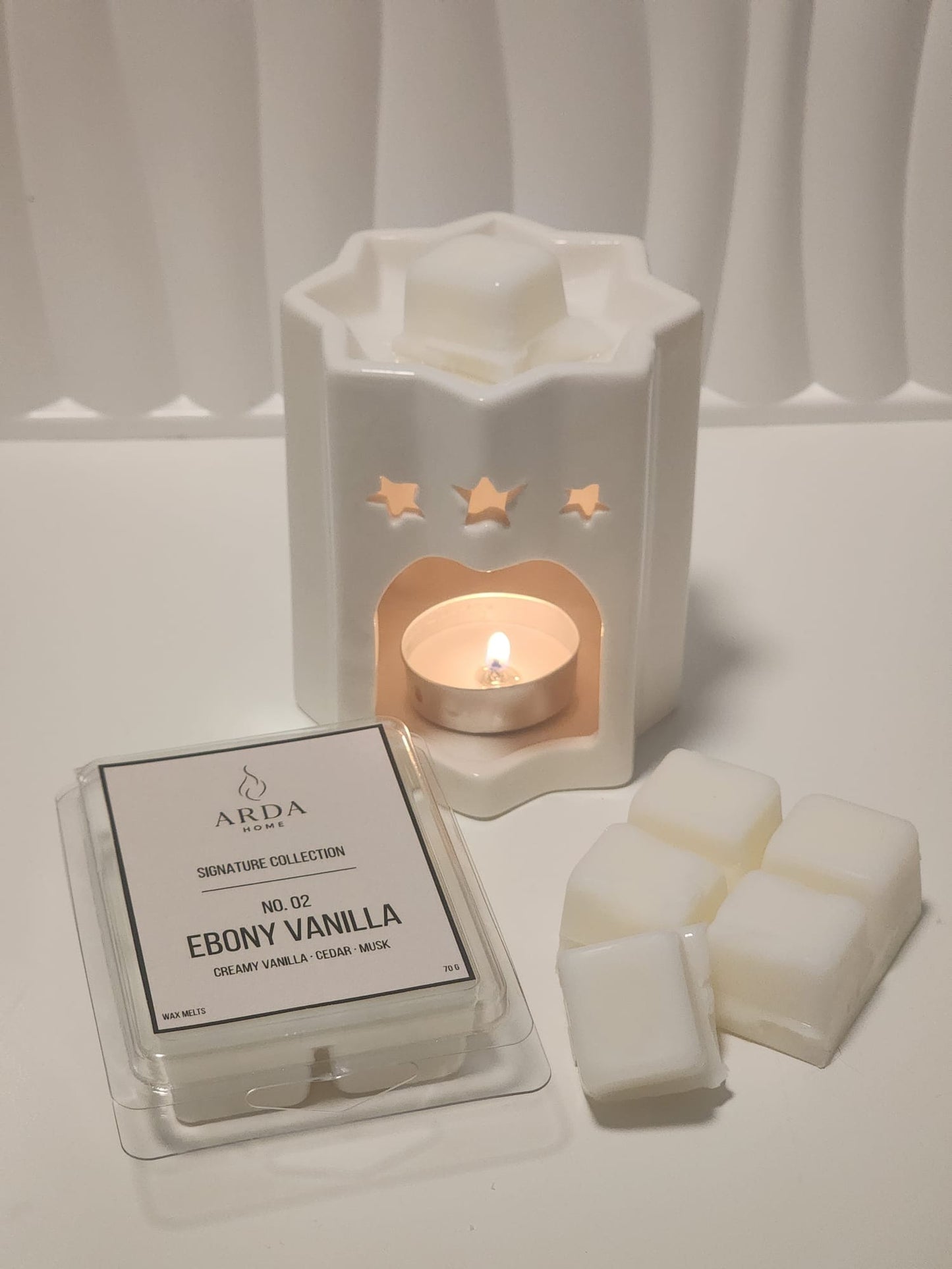 Tableta de wax melts Nº02 Ebony Vanilla de ARDA HOME junto a un quemador cerámico.